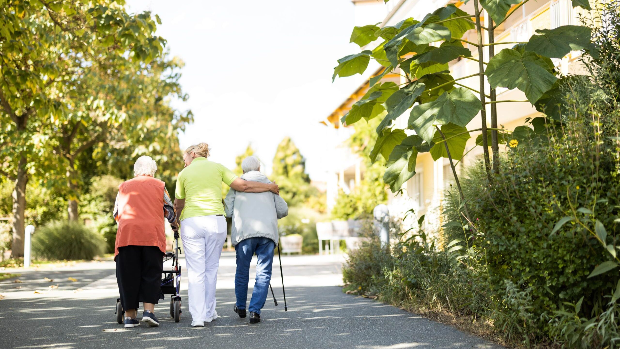 Alltag im Garten - Pflegerin mit zwei Senioren