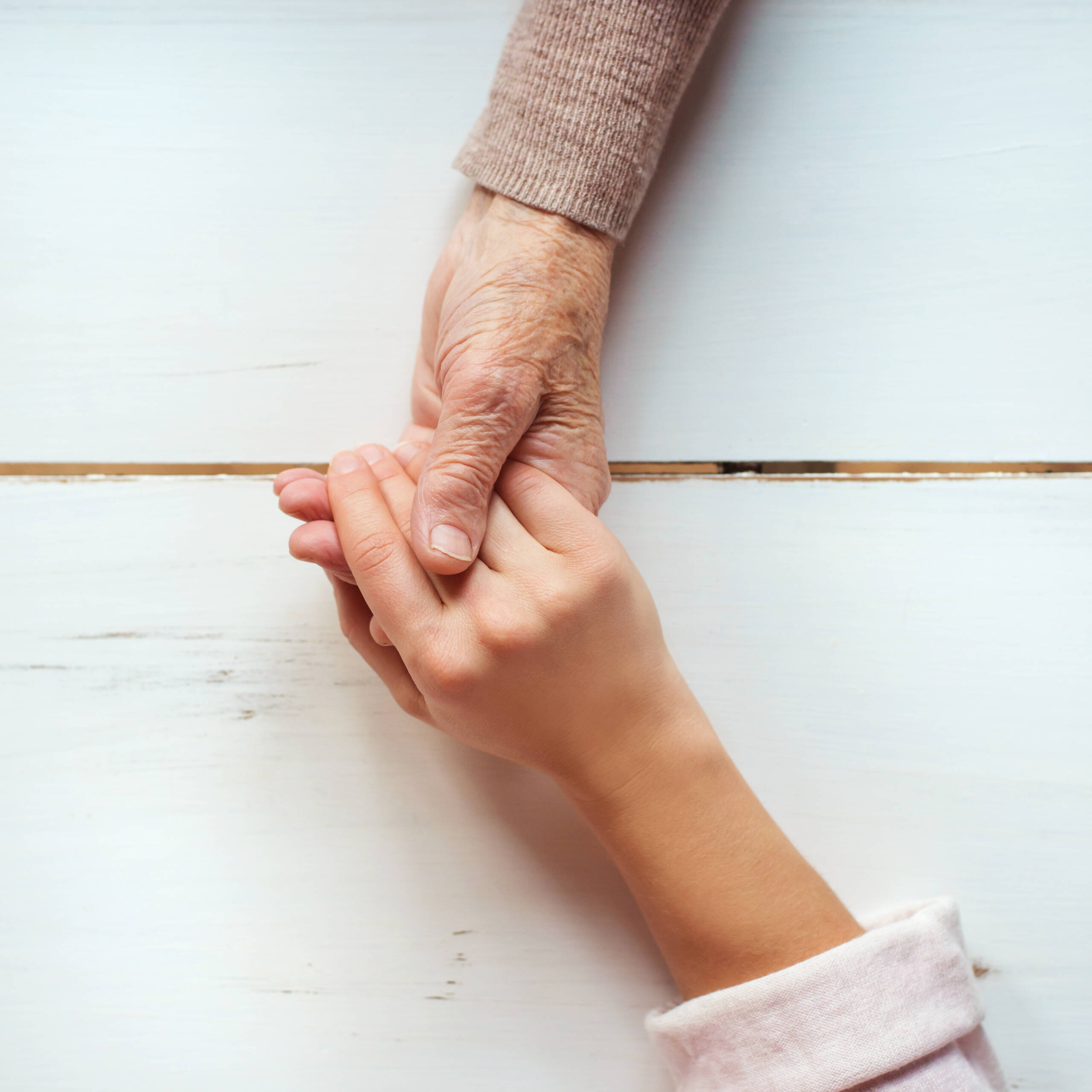Ältere Hand hält jüngere Hand