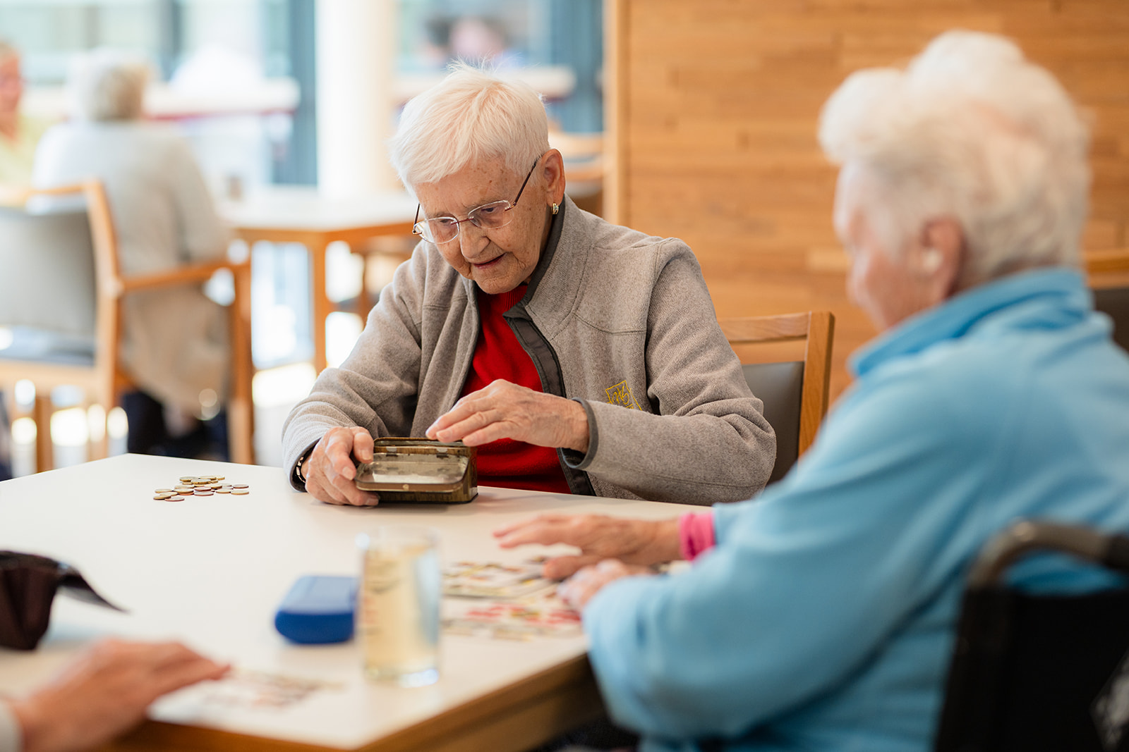 Startseite 11 Mann in Rollstuhl und zwei Frauen lachen im Hintergrund